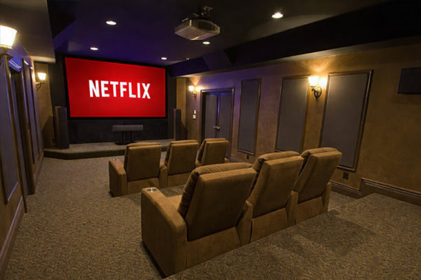 Home theater with brown recliner seats and a large screen displaying the Netflix logo.