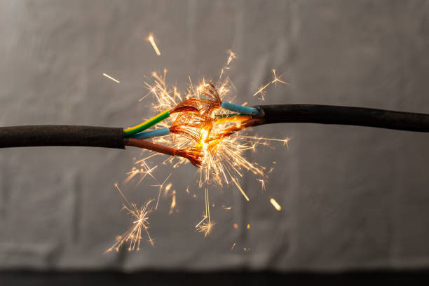 Two electrical wires with a spark in the middle