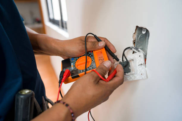 Electrician working on electrical wiring with a multimeter